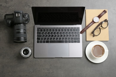 Photographer's workplace with laptop and camera on table, top view