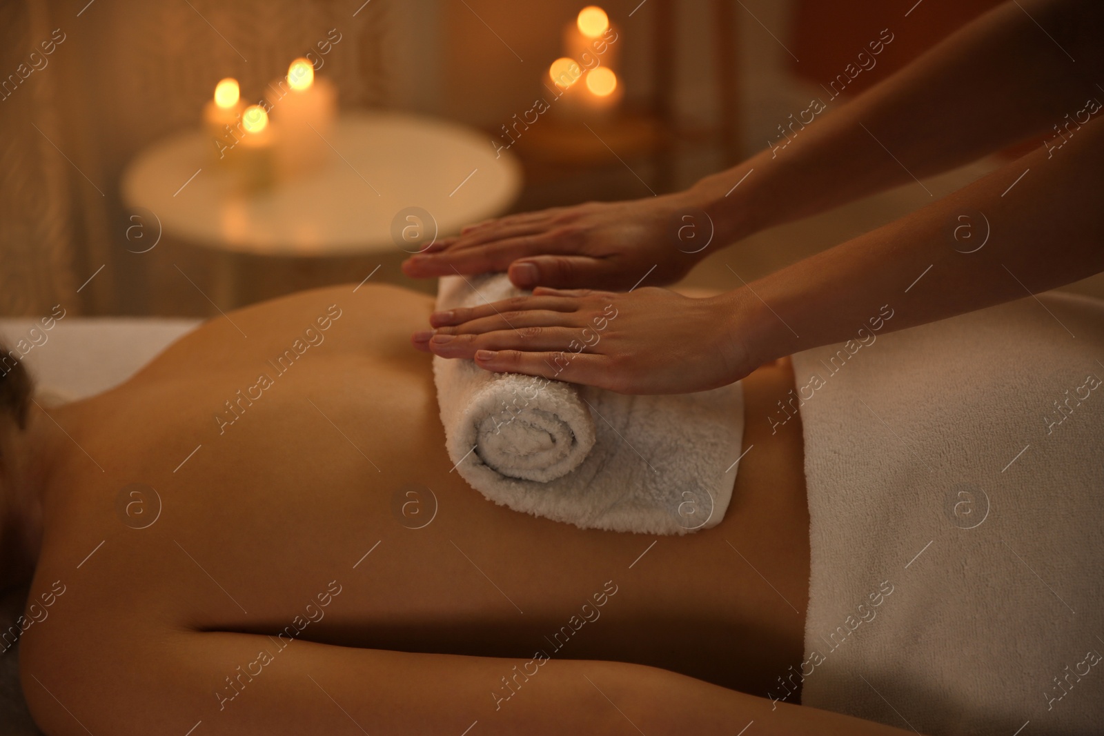 Photo of Young woman receiving hot towel massage in spa salon, closeup