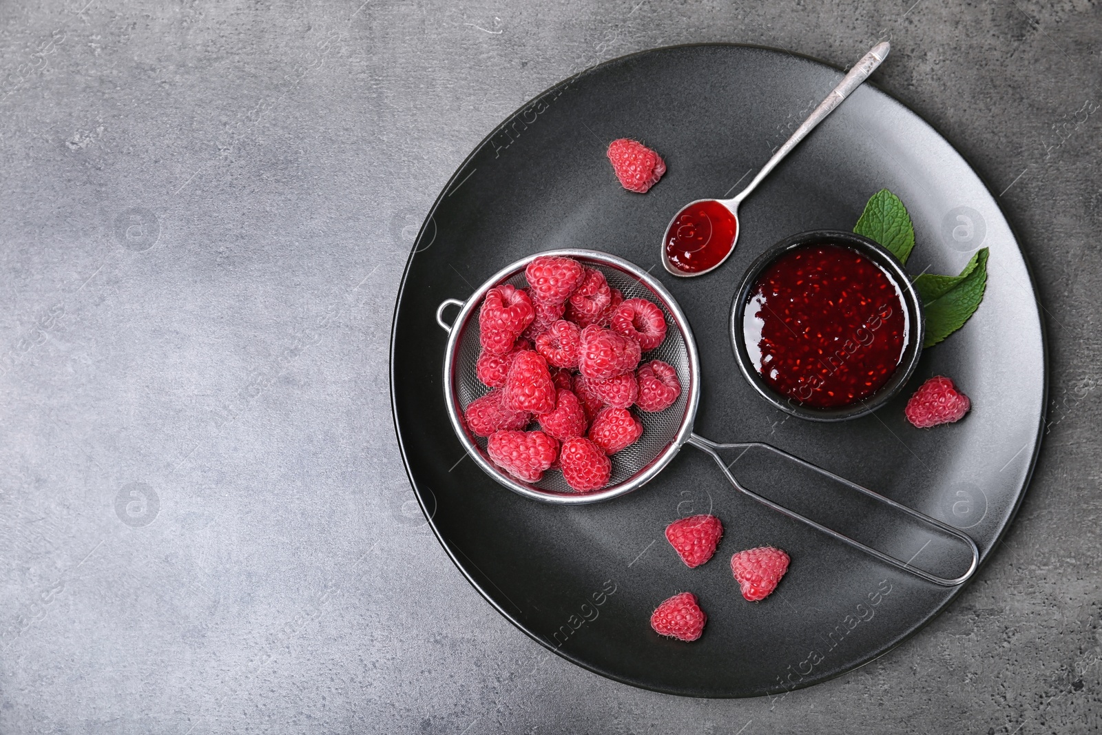 Photo of Flat lay composition with delicious raspberry jam on grey background