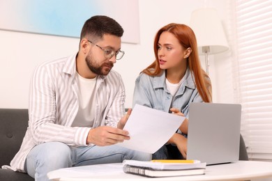 Photo of Couple doing taxes at table in living room