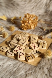 Many wooden runes and dried flowers on fur