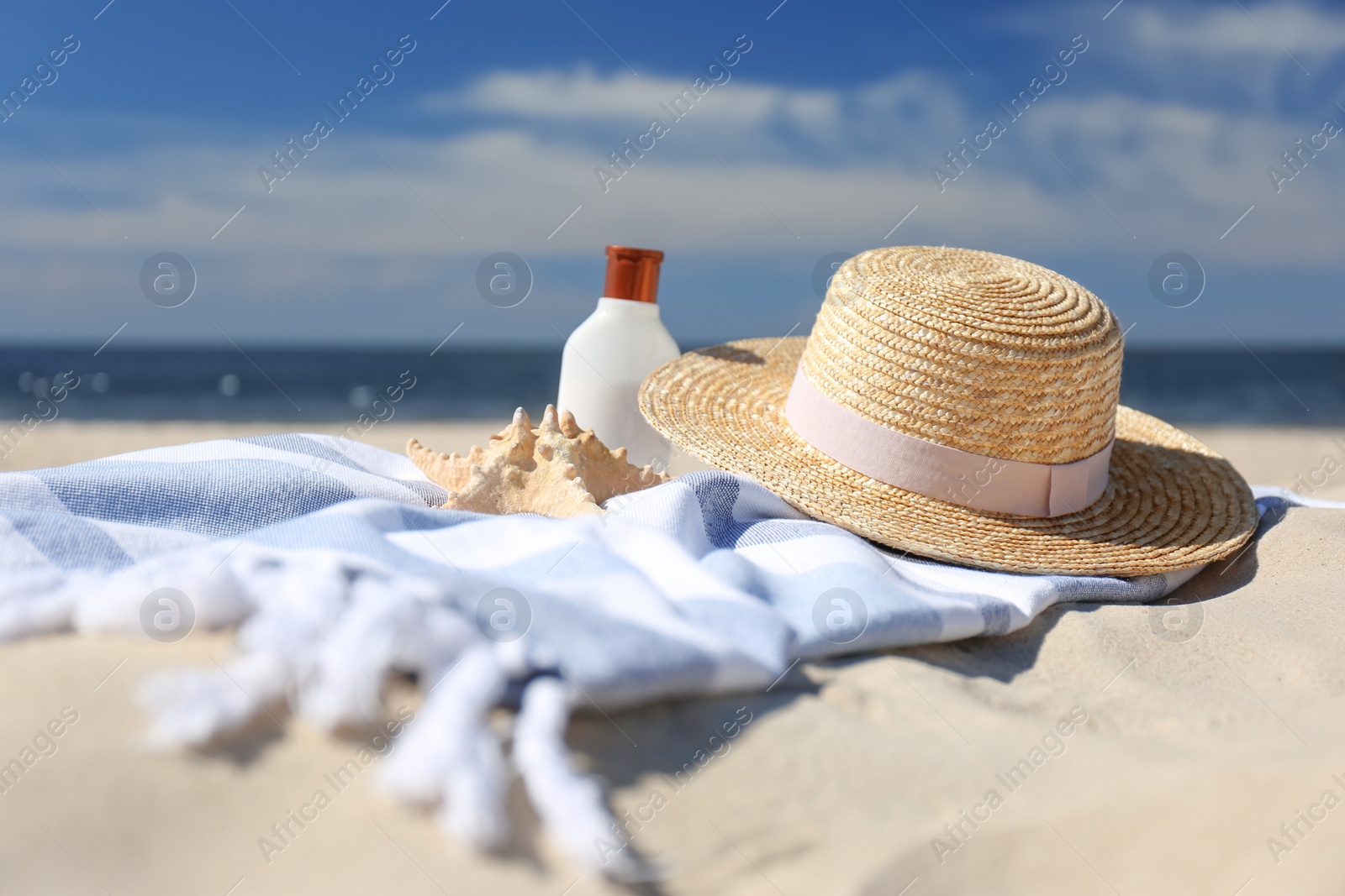 Photo of Stylish beach accessories for summer vacation on sand near sea