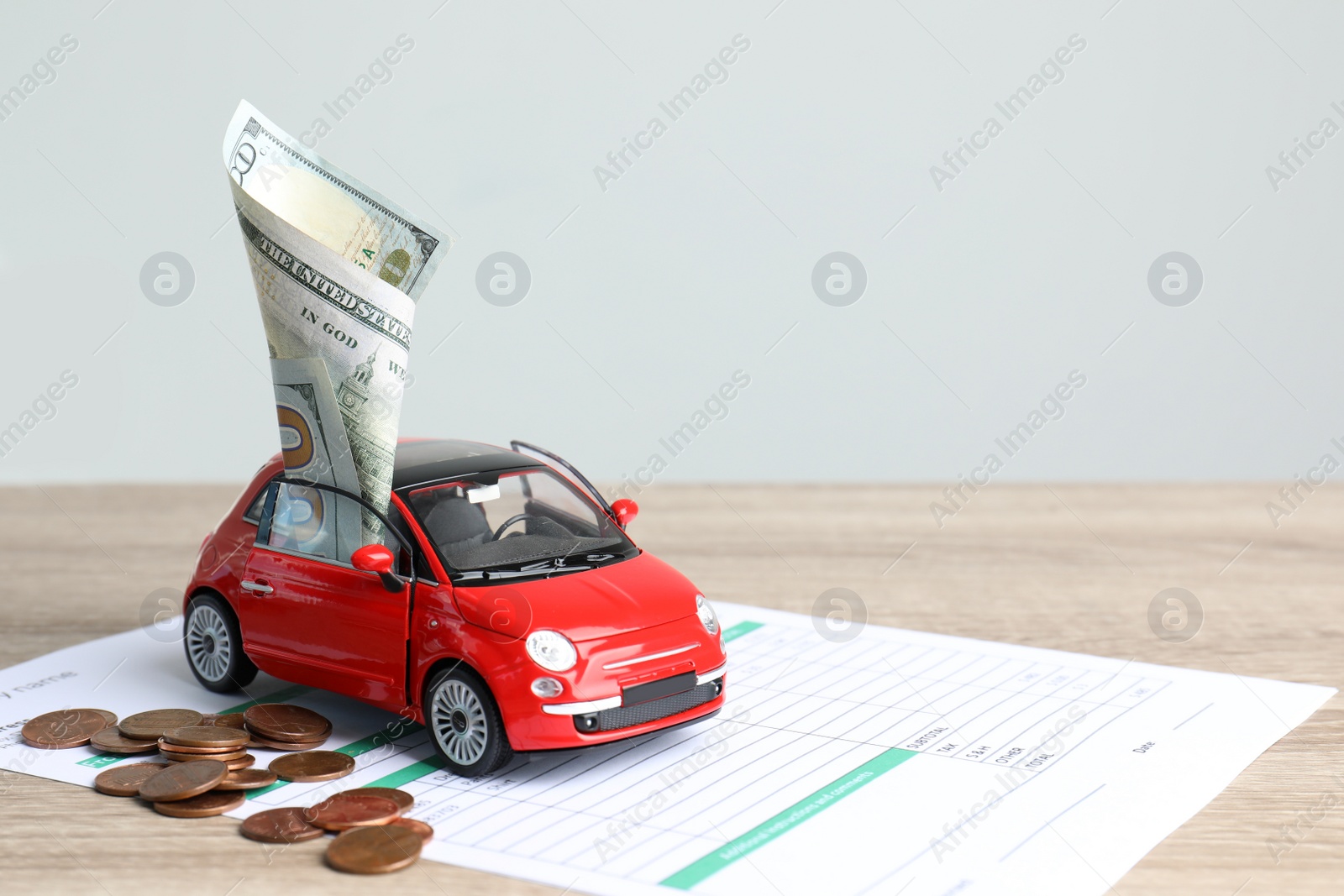 Photo of Toy car, money and insurance contract on table. Space for text