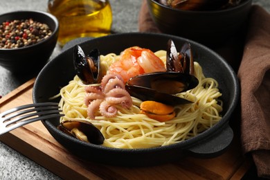 Photo of Delicious pasta with sea food served on grey table