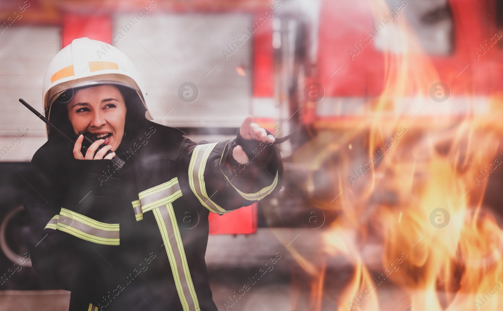 Image of Firefighter in uniform using portable radio set near fire truck outdoors