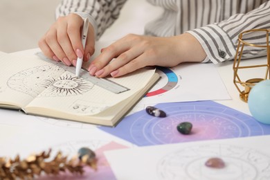 Photo of Astrologer using zodiac wheel for fate forecast at table, closeup. Fortune telling