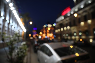 Blurred view of beautiful cityscape with glowing streetlights and cars at night