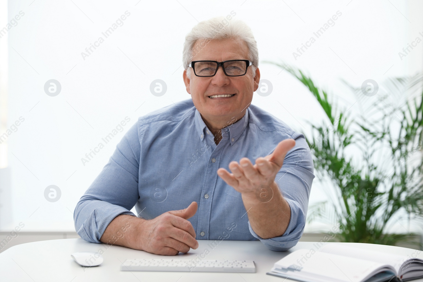 Photo of Mature man using video chat in office, view from web camera