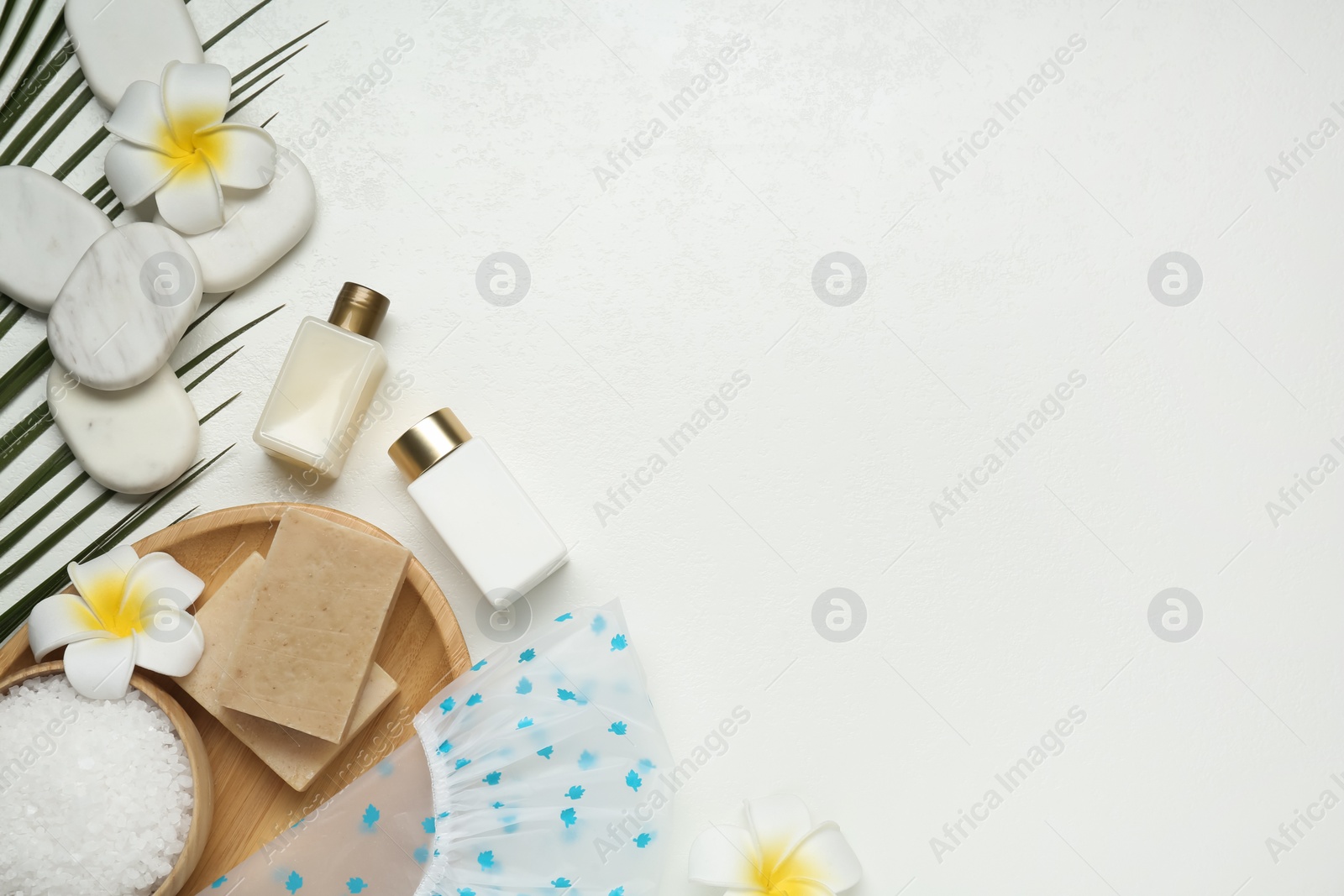 Photo of Flat lay composition with shower cap and toiletries on white wooden background. Space for text