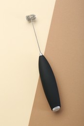 Black milk frother wand on color background, top view