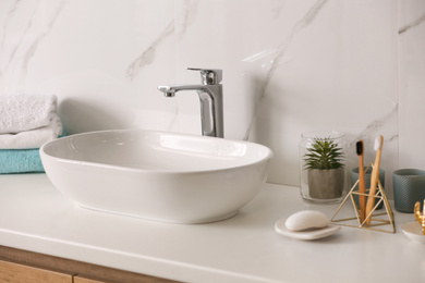 Stylish vessel sink on light countertop in modern bathroom