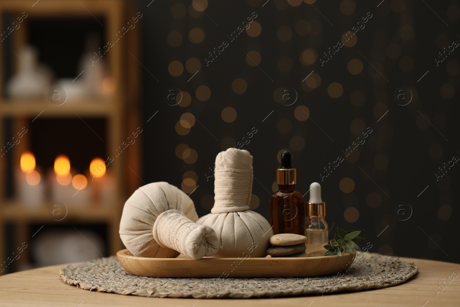 Photo of Spa composition. Herbal sacks, cosmetic products and stones on table indoors. Space for text