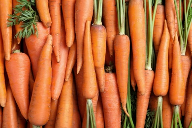 Tasty raw carrots as background, top view
