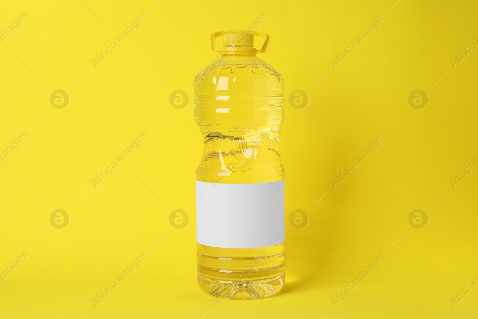 Photo of Bottle of cooking oil on yellow background