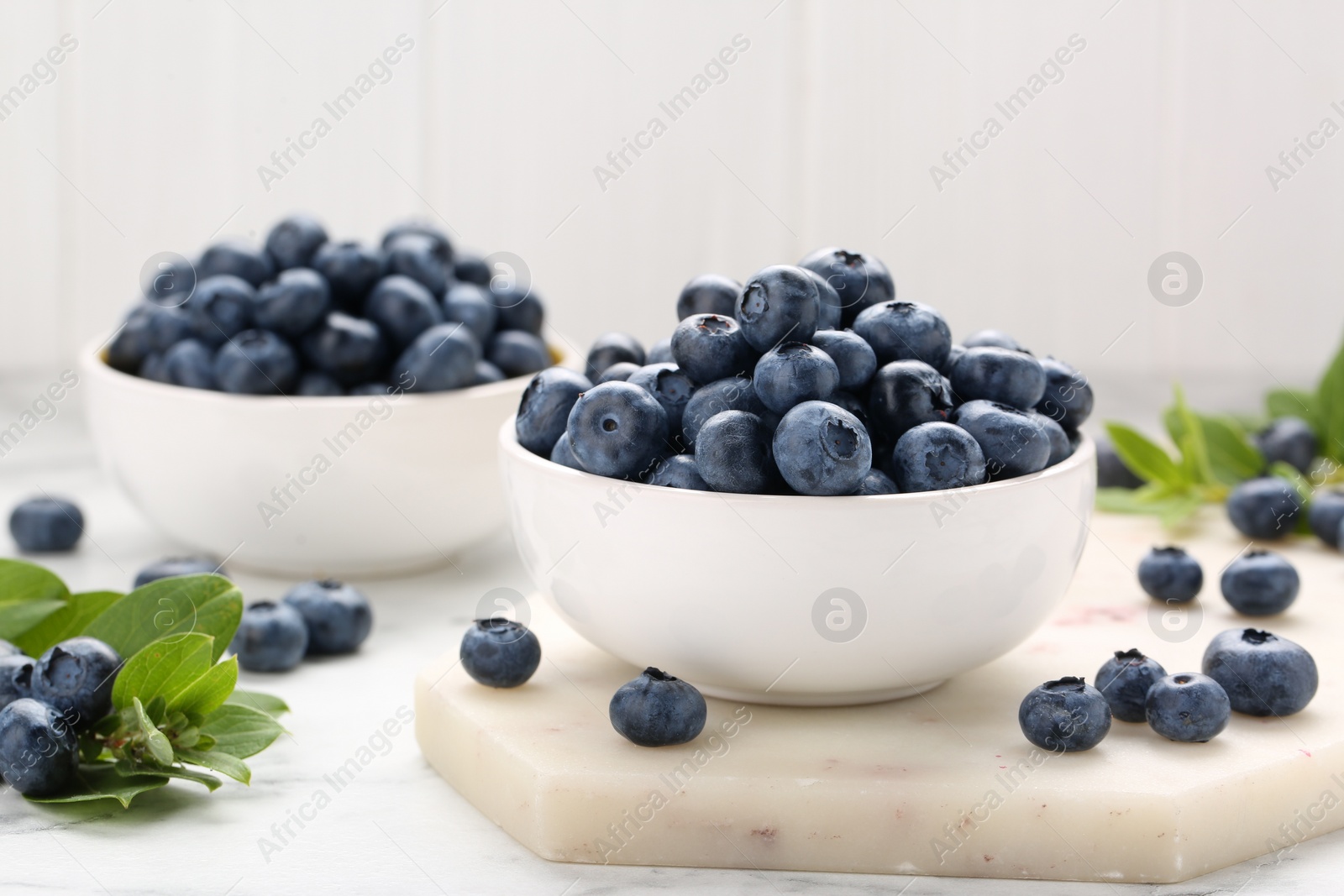 Photo of Tasty fresh blueberries on white table, closeup