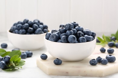 Tasty fresh blueberries on white table, closeup