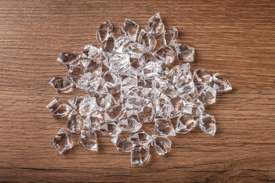 Photo of Pile of crushed ice on wooden table, top view