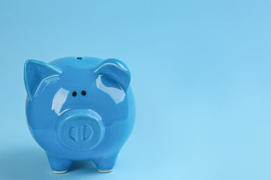 Photo of Piggy bank on light blue background. Space for text
