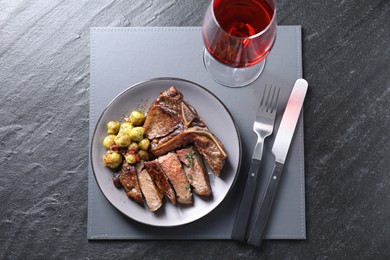 Photo of Delicious fried beef meat and vegetables served on black table, top view