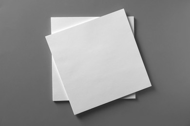 Photo of Stack of blank paper sheets for brochure on light grey background, top view