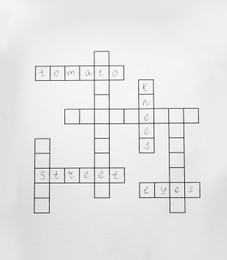 Photo of Blank crossword isolated on white, top view. Intellectual entertainment