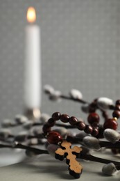 Photo of Rosary beads and willow branches on table, closeup