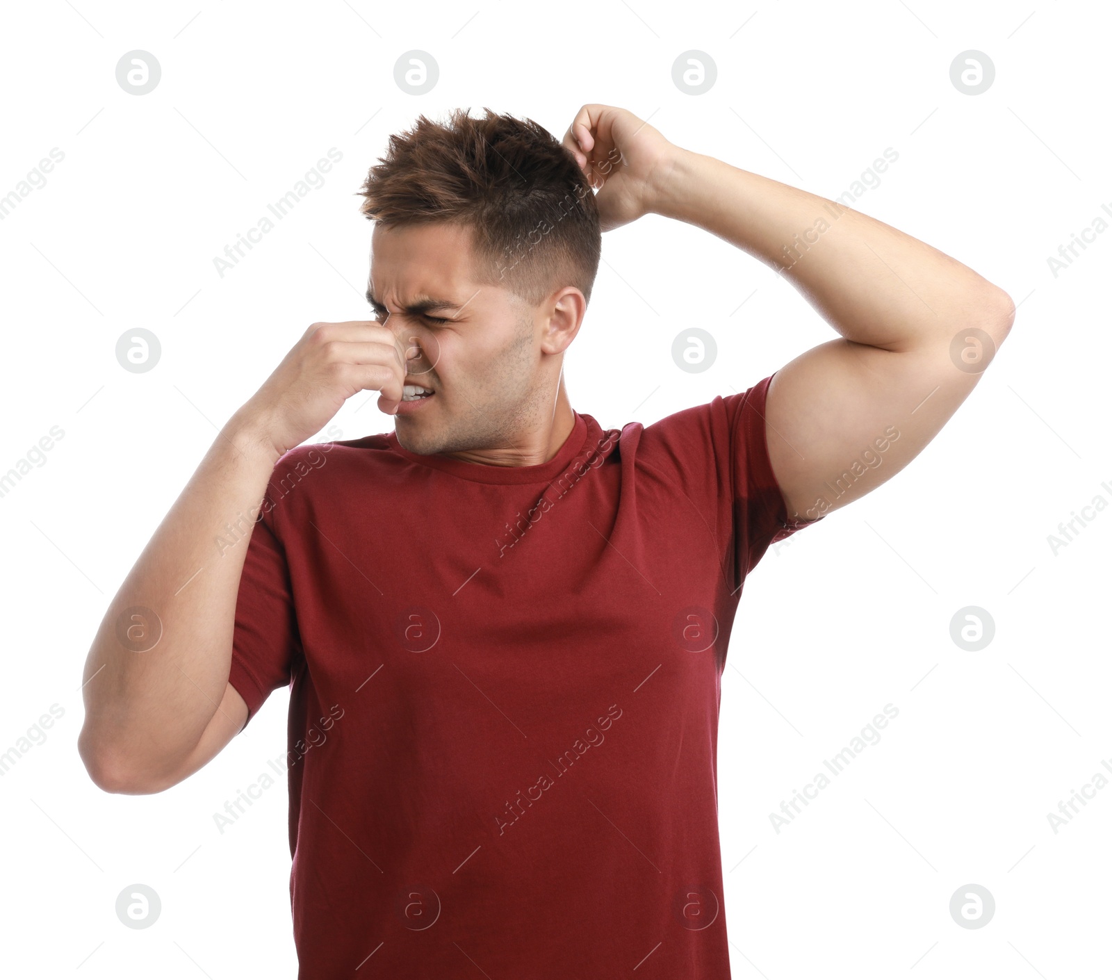 Photo of Young man with sweat stain on his clothes against white background. Using deodorant