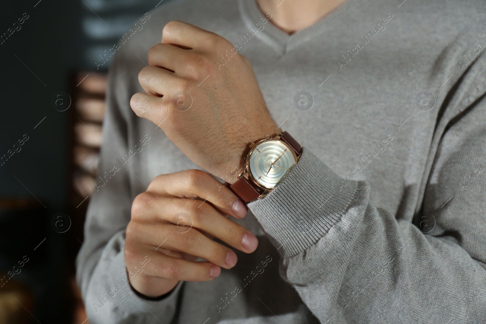 Photo of Man with luxury wrist watch on blurred background, closeup