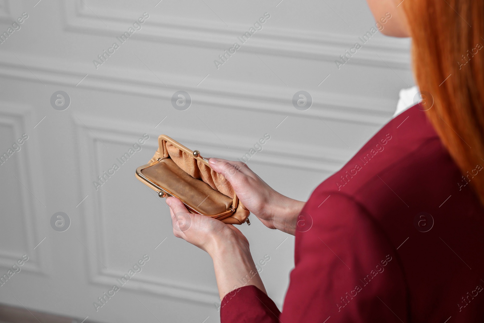 Photo of Woman with empty wallet near white wall, closeup