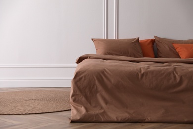 Bed with orange and brown linens in stylish room