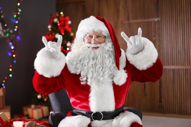 Photo of Authentic Santa Claus showing funny gestures indoors