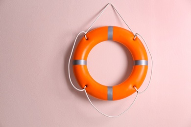 Orange lifebuoy on pink background. Rescue equipment