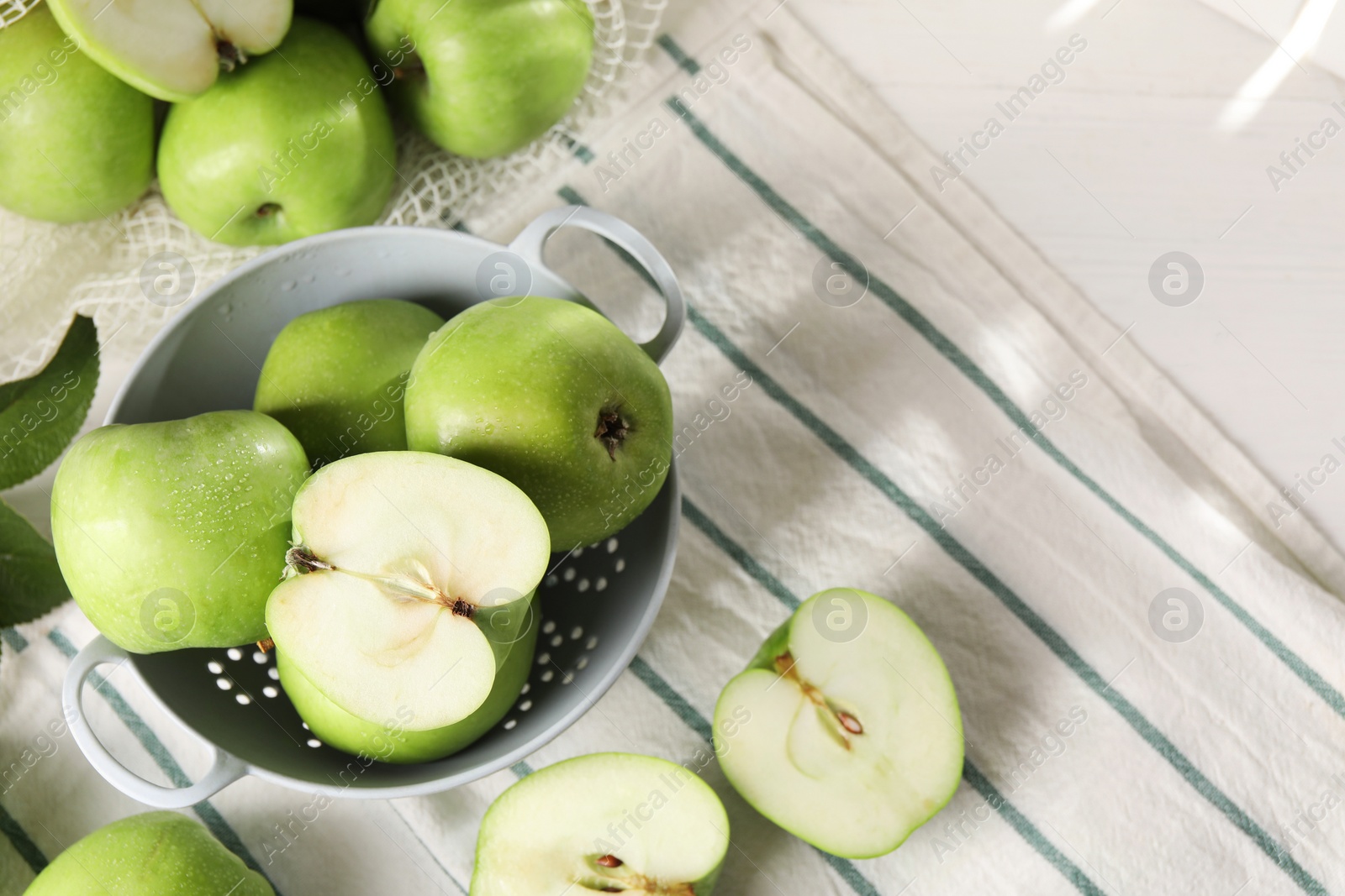 Photo of Fresh green apples with water drops on white wooden table, above view. Space for text