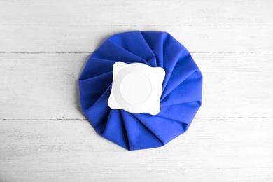Ice pack on white wooden table, top view