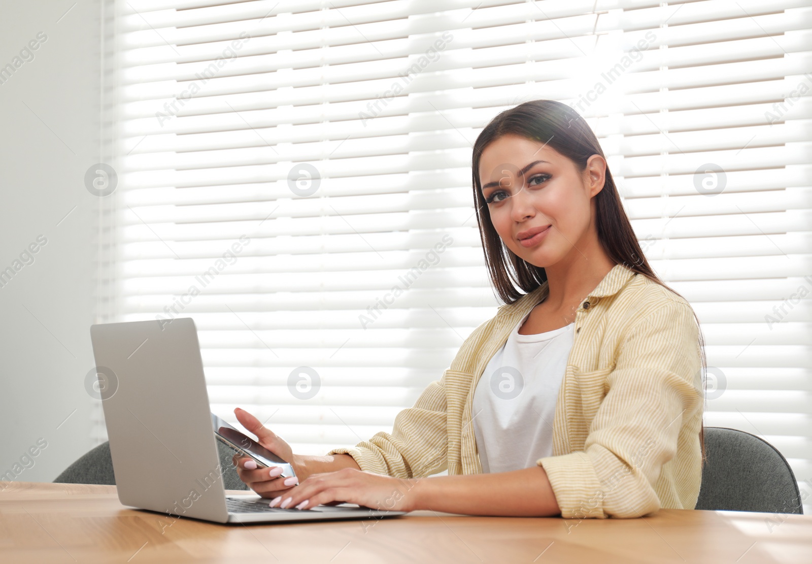 Photo of Young woman working with laptop in office