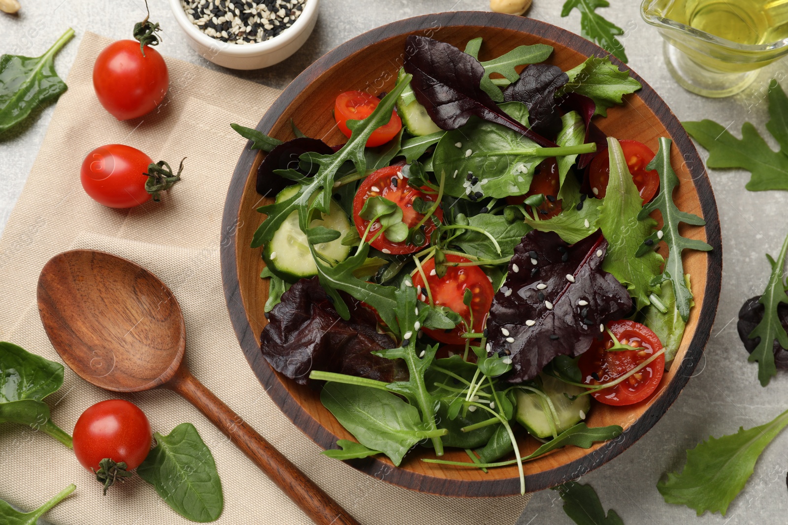 Photo of Tasty fresh vegetarian salad and ingredients on grey table, flat lay