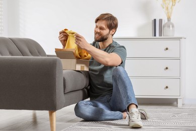 Photo of Happy man with parcel at home. Internet shopping