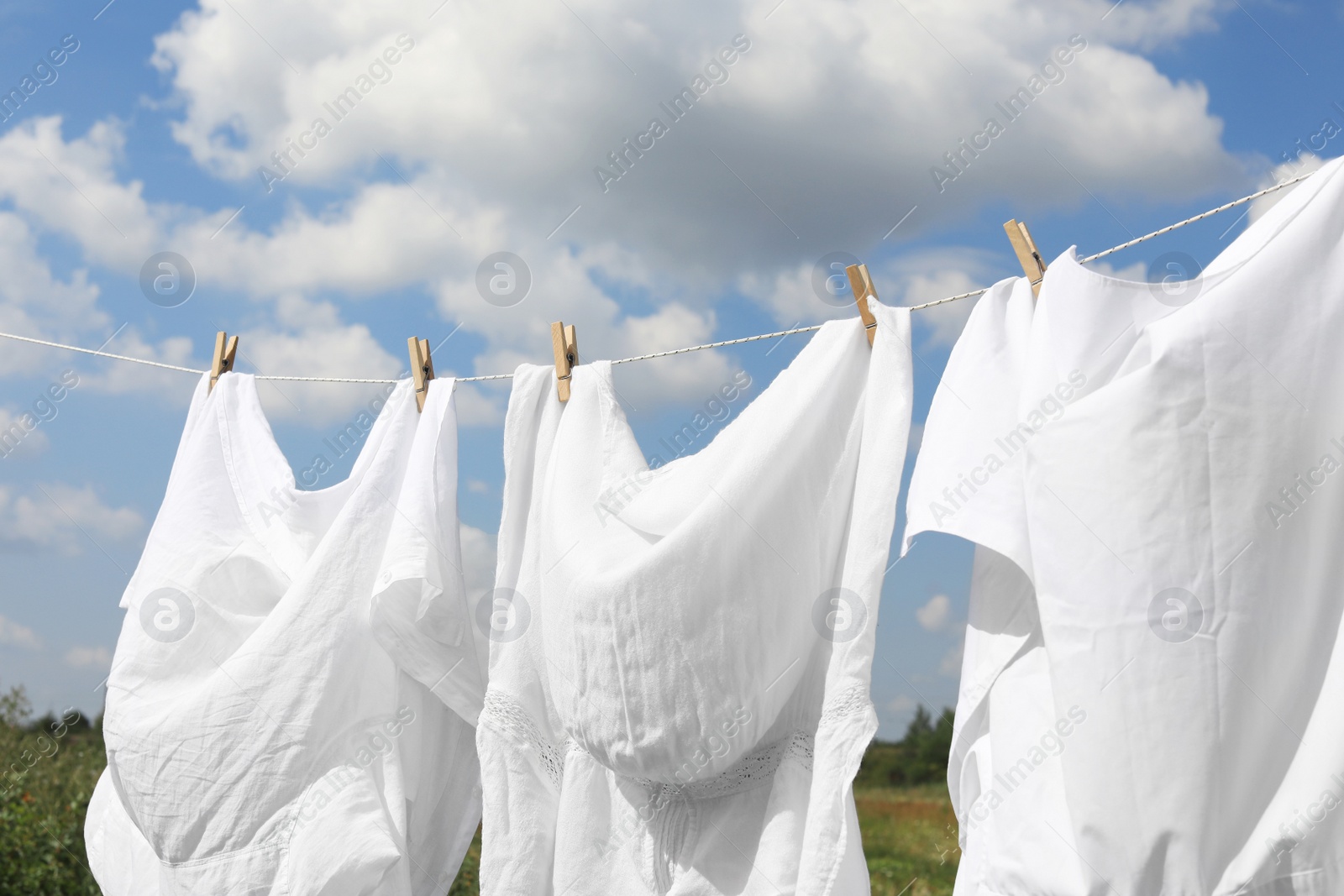 Photo of Clean clothes hanging on washing line outdoors. Drying laundry