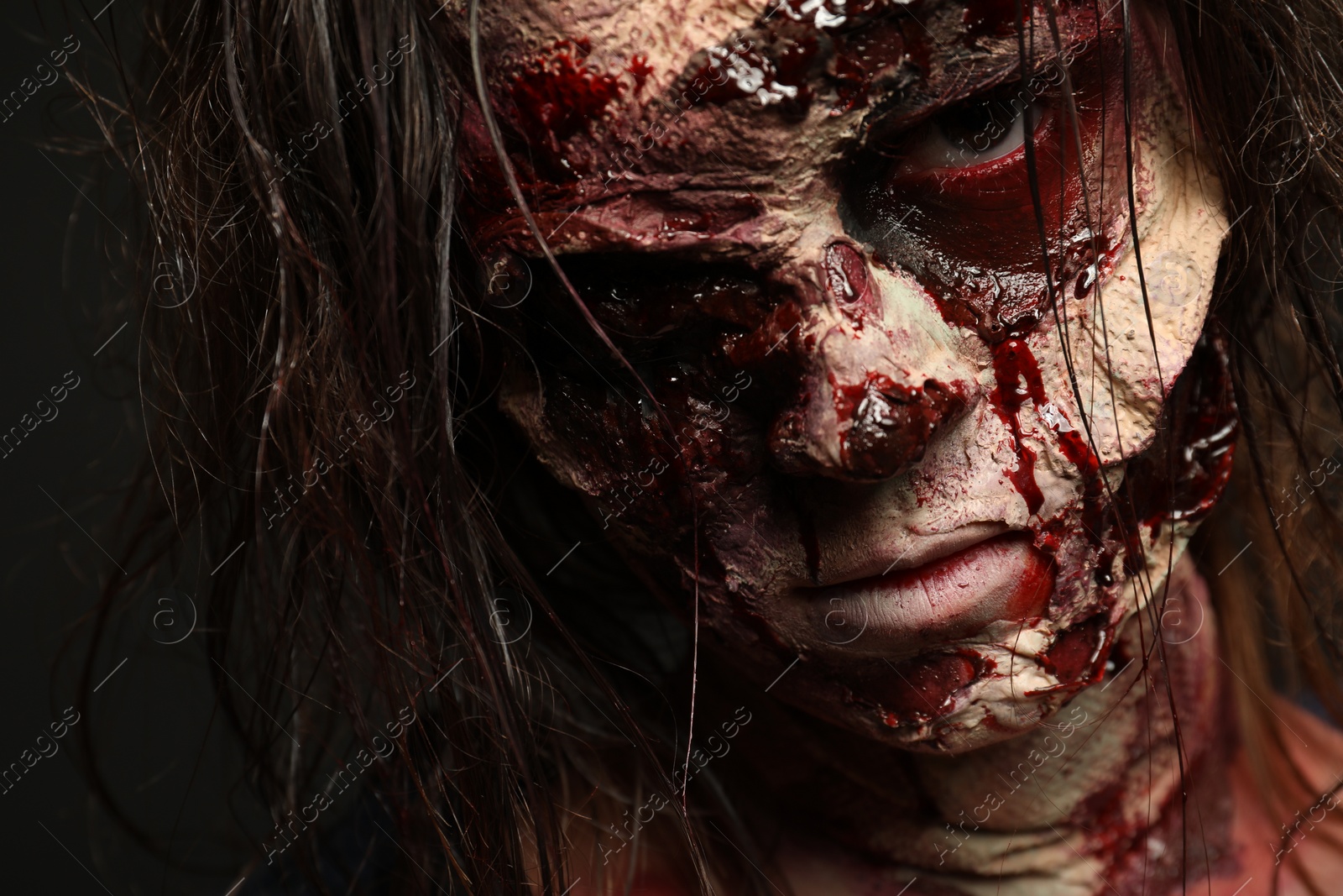 Photo of Scary zombie on dark background, closeup. Halloween monster