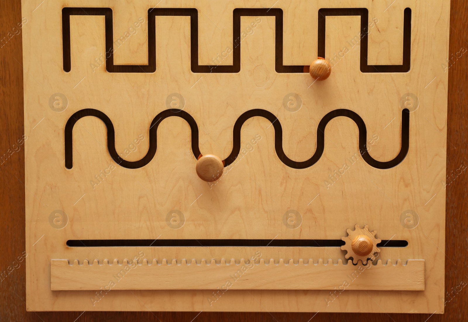 Photo of Wooden sliding maze with different lines on table. Montessori toy