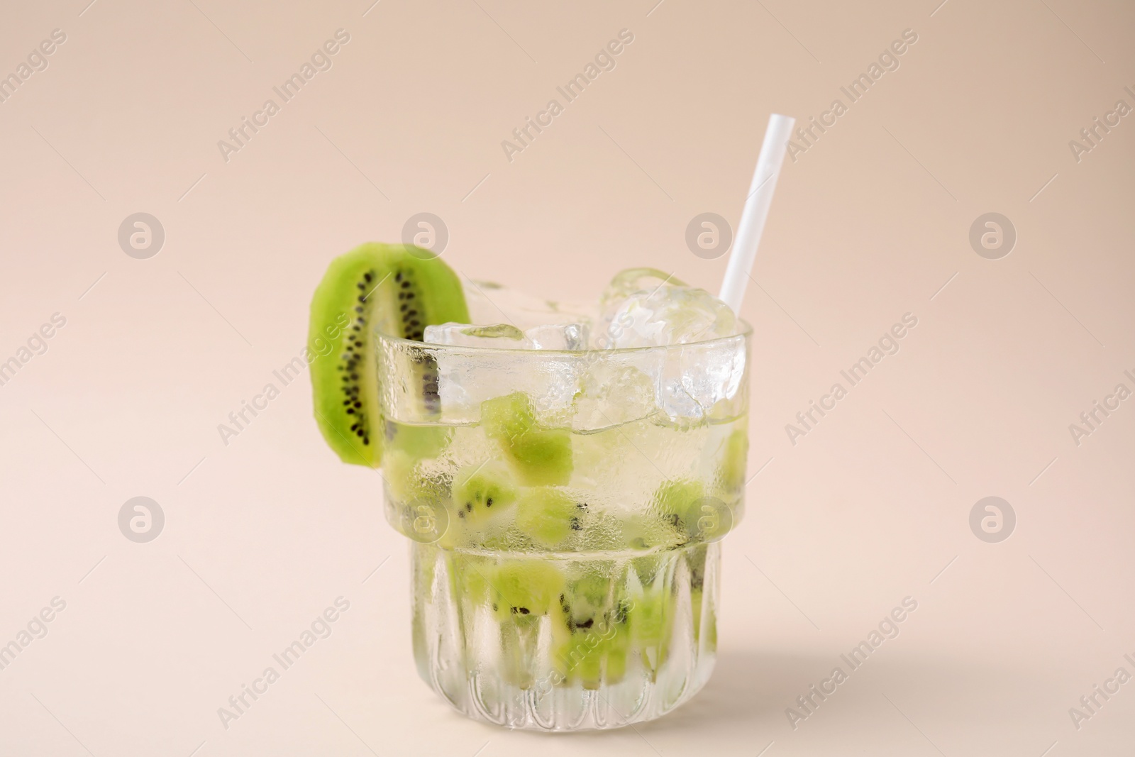 Photo of Glass of refreshing drink with kiwi on beige background