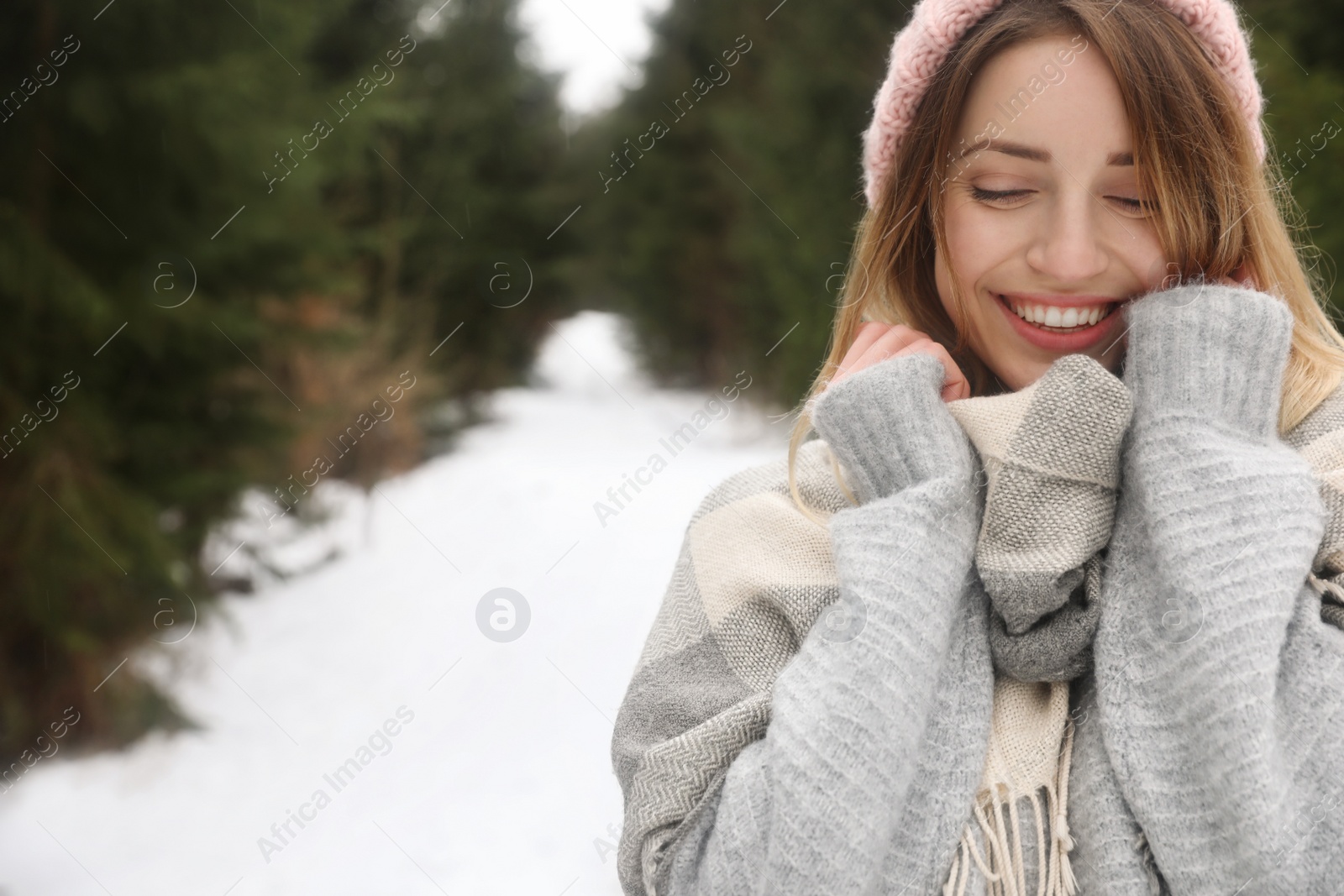 Photo of Young woman in snowy conifer forest, space for text. Winter vacation