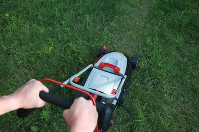 Photo of Man cutting grass with lawn mower in garden, above view