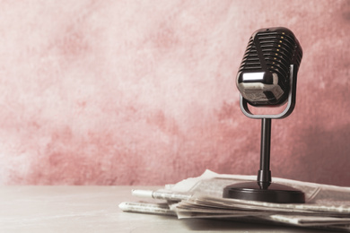 Newspapers and vintage microphone on table, space for design. Journalist's work