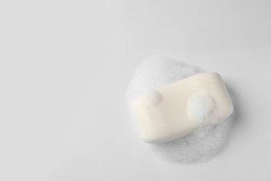 Soap with fluffy foam on white background, top view