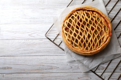 Photo of Freshly baked rhubarb pie on light wooden table, top view. Space for text