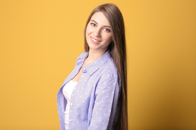 Photo of Portrait of young woman with long beautiful hair on color background