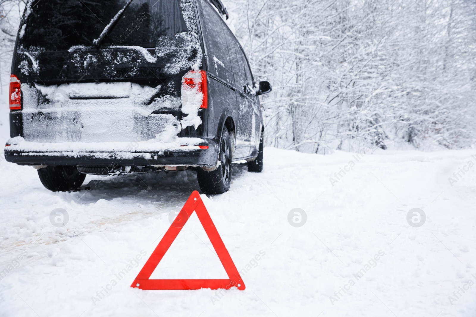 Photo of Emergency stop sign and modern car on snowy road