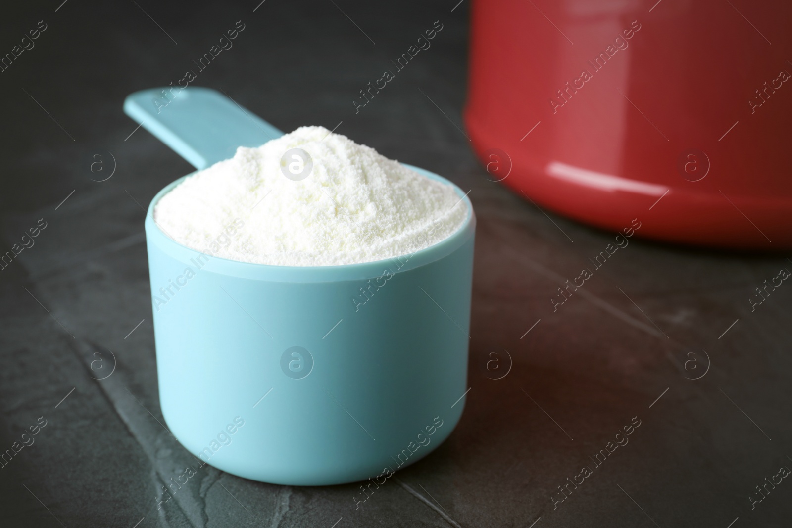 Photo of Scoop of protein powder on grey stone table