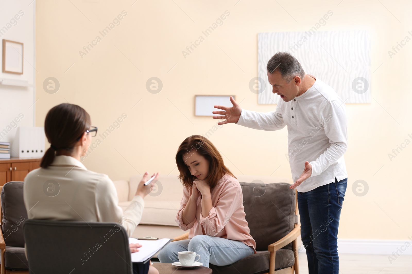 Photo of Psychotherapist working with couple in office. Family counselling